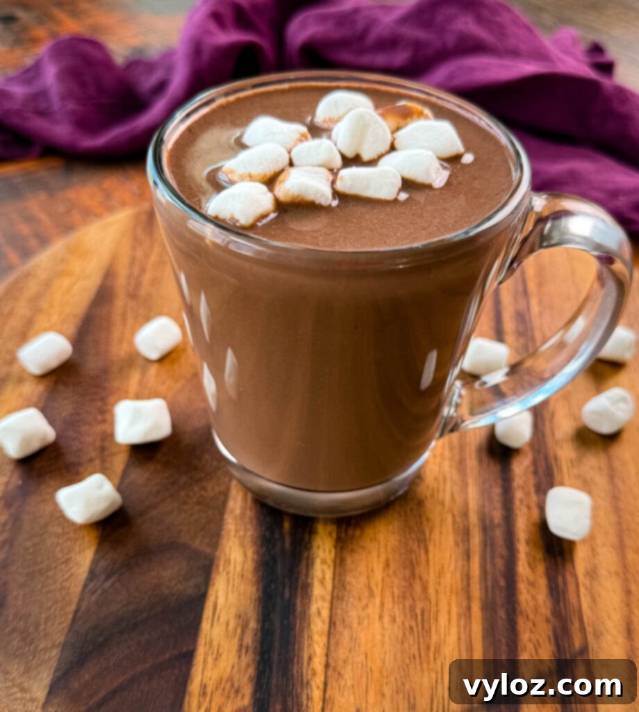 A festive mug filled with slow cooker Crockpot hot chocolate, generously topped with fluffy marshmallows, ready for a holiday treat.
