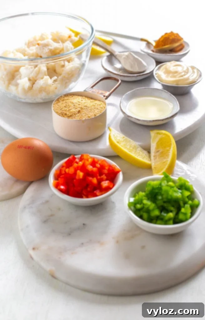 Quick and Crispy Air Fryer Crab Cakes 3 A vibrant display of fresh ingredients for crab cakes including diced red and green peppers, lemon, creamy mayonnaise, garlic, and a bowl of high-quality lump crab meat