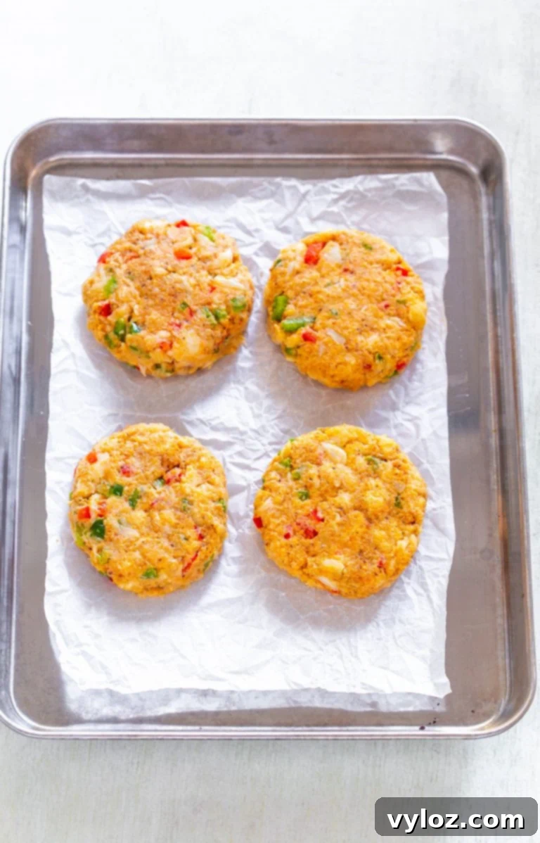 Quick and Crispy Air Fryer Crab Cakes 6 Uncooked crab cake patties meticulously arranged in an air fryer basket, perfectly spaced for optimal air circulation