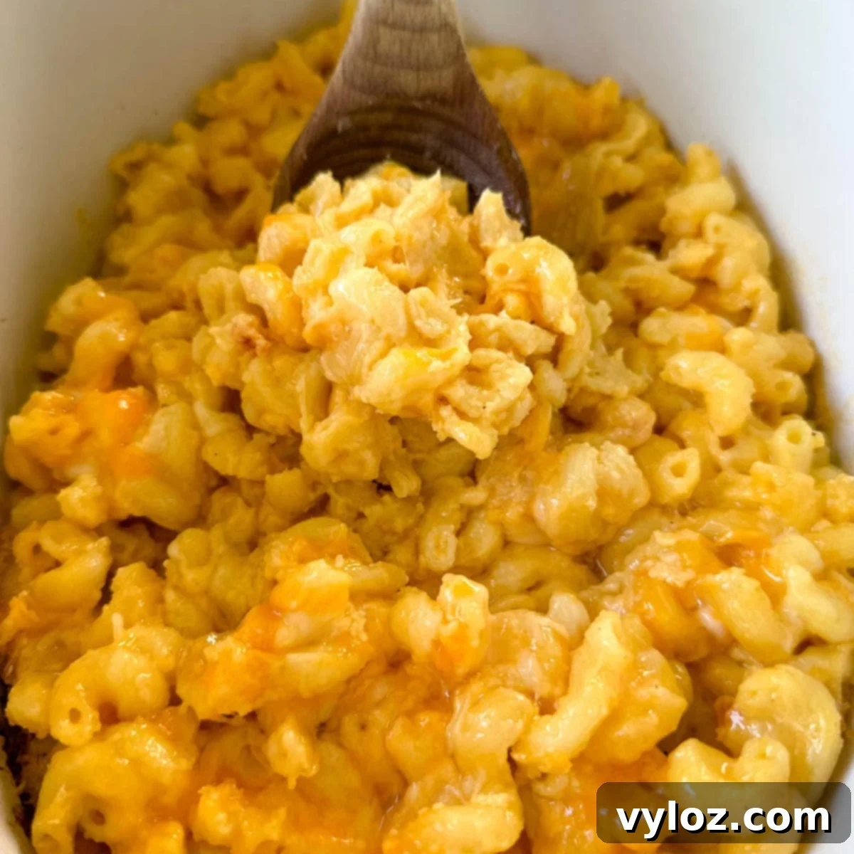 A slow cooker filled with creamy Crockpot mac and cheese, ready to be served, highlighting its rich, cheesy consistency.