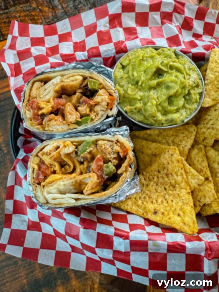 Ultimate Creamy Protein Chicken Burrito 12 A stack of high-protein chicken burritos wrapped in foil, ready for storage