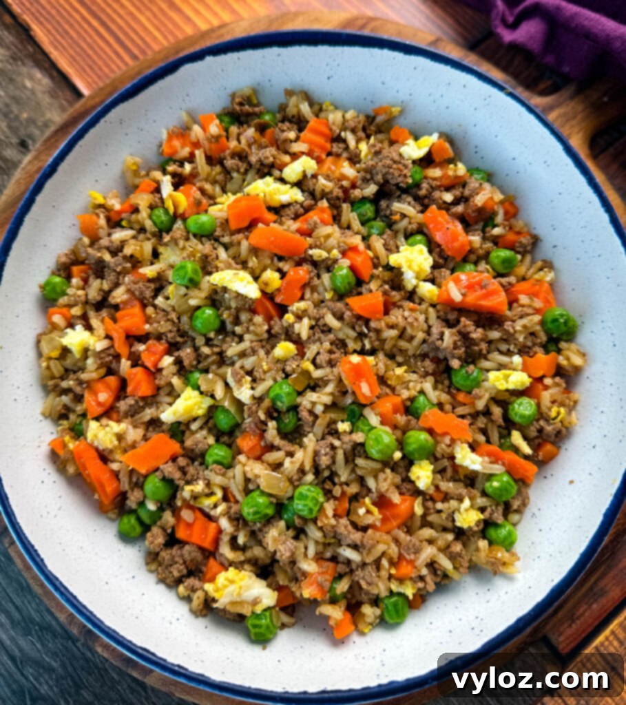 Another perspective of ground beef fried rice in a white bowl, showcasing the textures and colors of the ingredients.