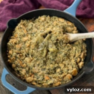creamy spinach artichoke chicken and rice in a skillet with a wooden spoon