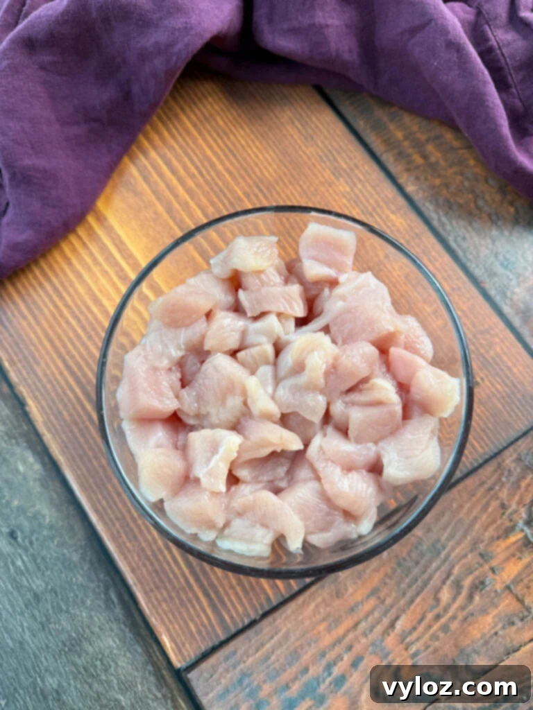 raw, boneless, skinless diced chicken breasts in a glass bowl