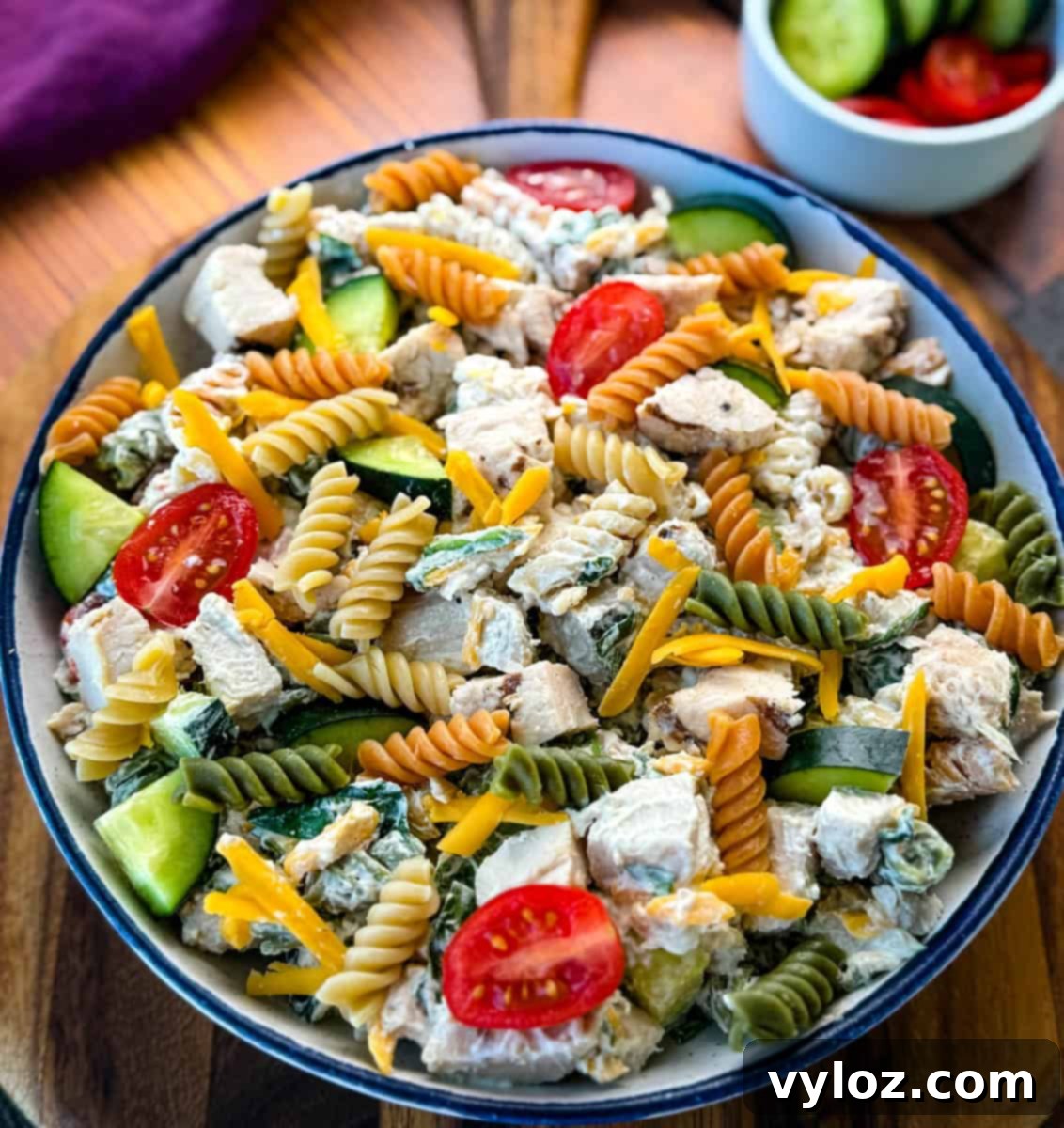 A final presentation of High-Protein Chicken Pasta Salad in a bowl, perfect for sharing, with a focus on fresh ingredients and rich texture.