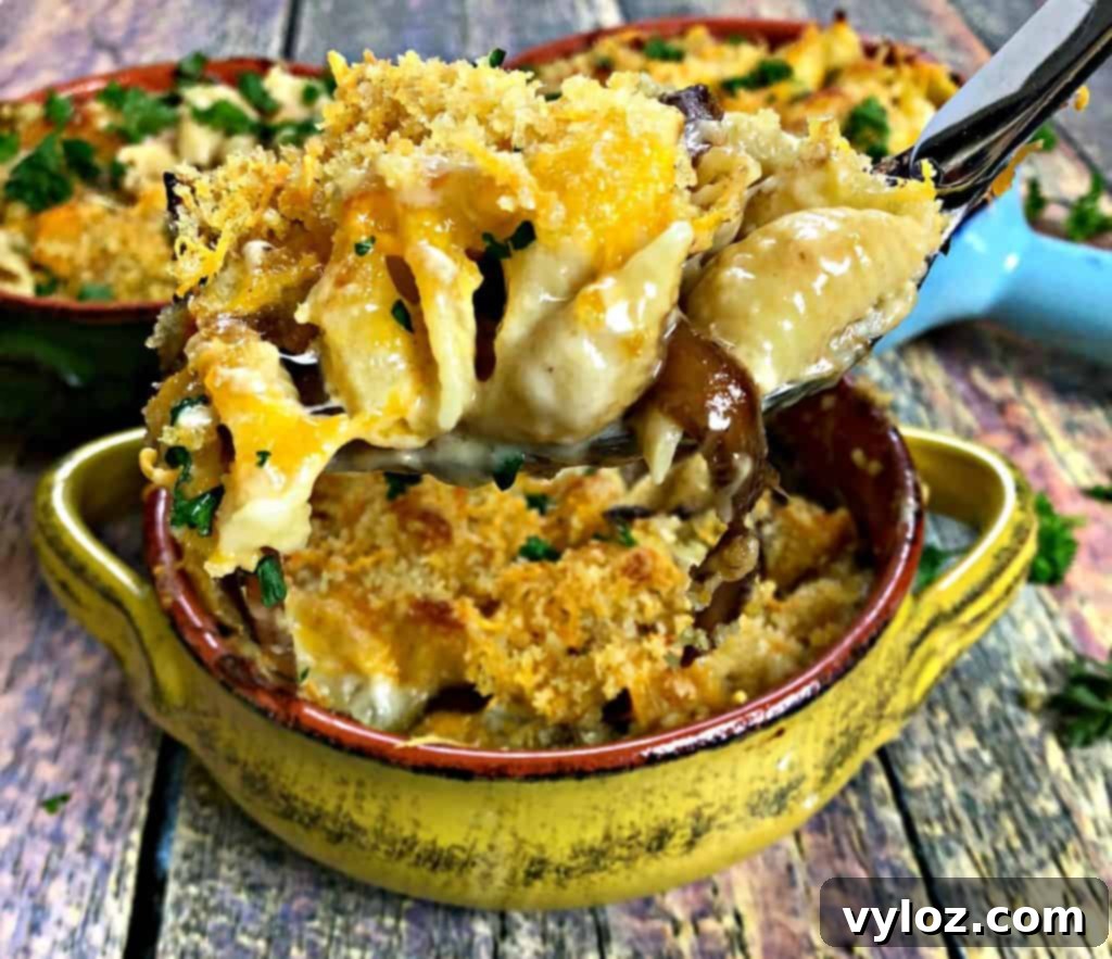 Caramelized Onion Mushroom Mac and Cheese Bake 11 A rustic wooden spoon digging into creamy baked macaroni and cheese