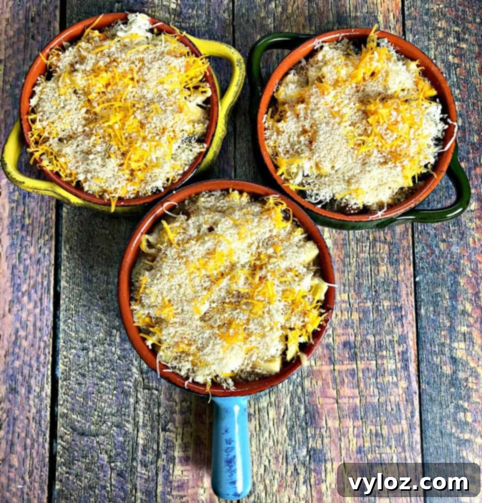 Caramelized Onion Mushroom Mac and Cheese Bake 5 Chef's hand adding freshly shredded cheese to a bowl of macaroni