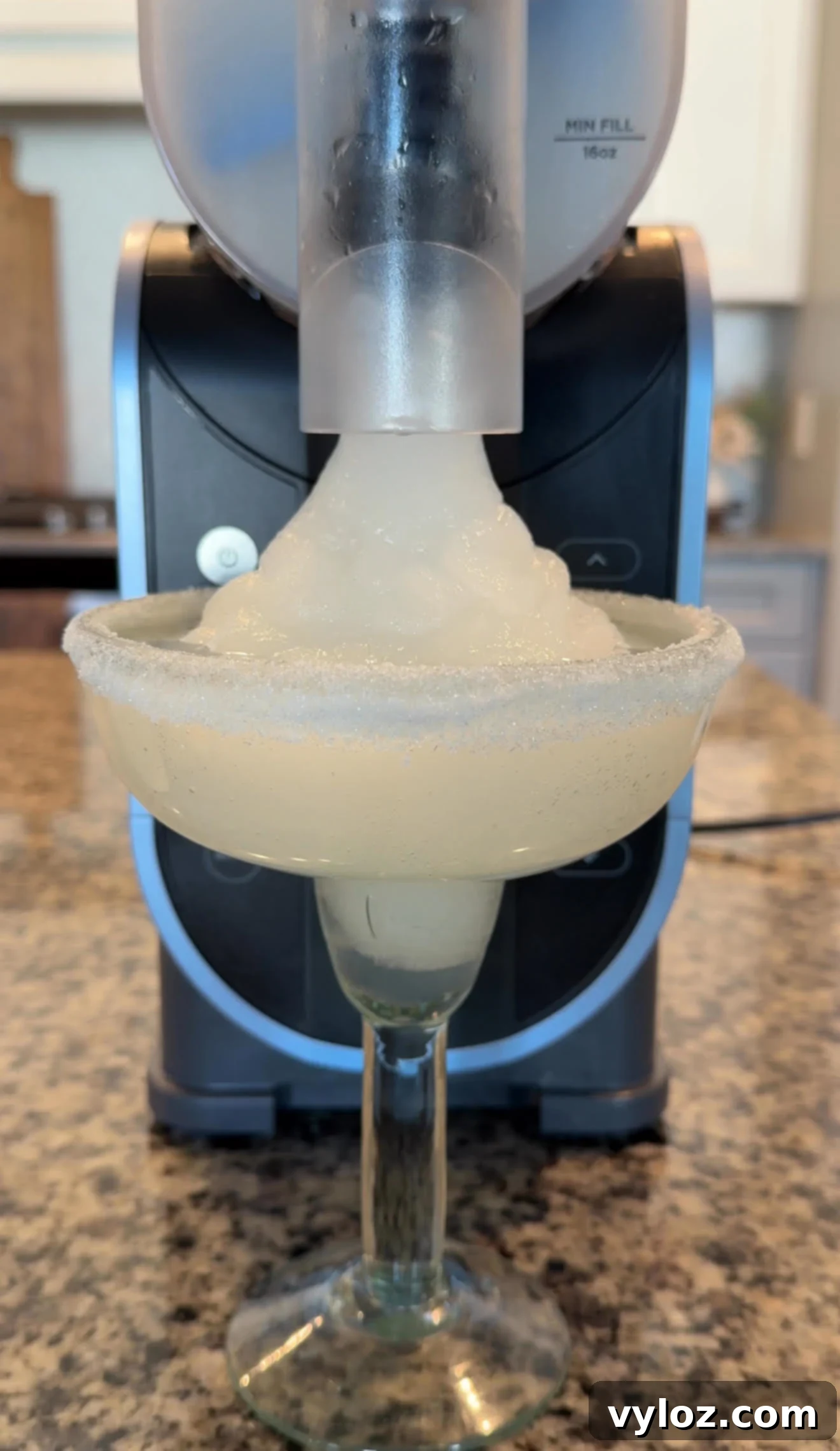 The Ninja Slushi Machine dispensing frozen margarita slush into a glass, with the icy drink forming a tall peak.