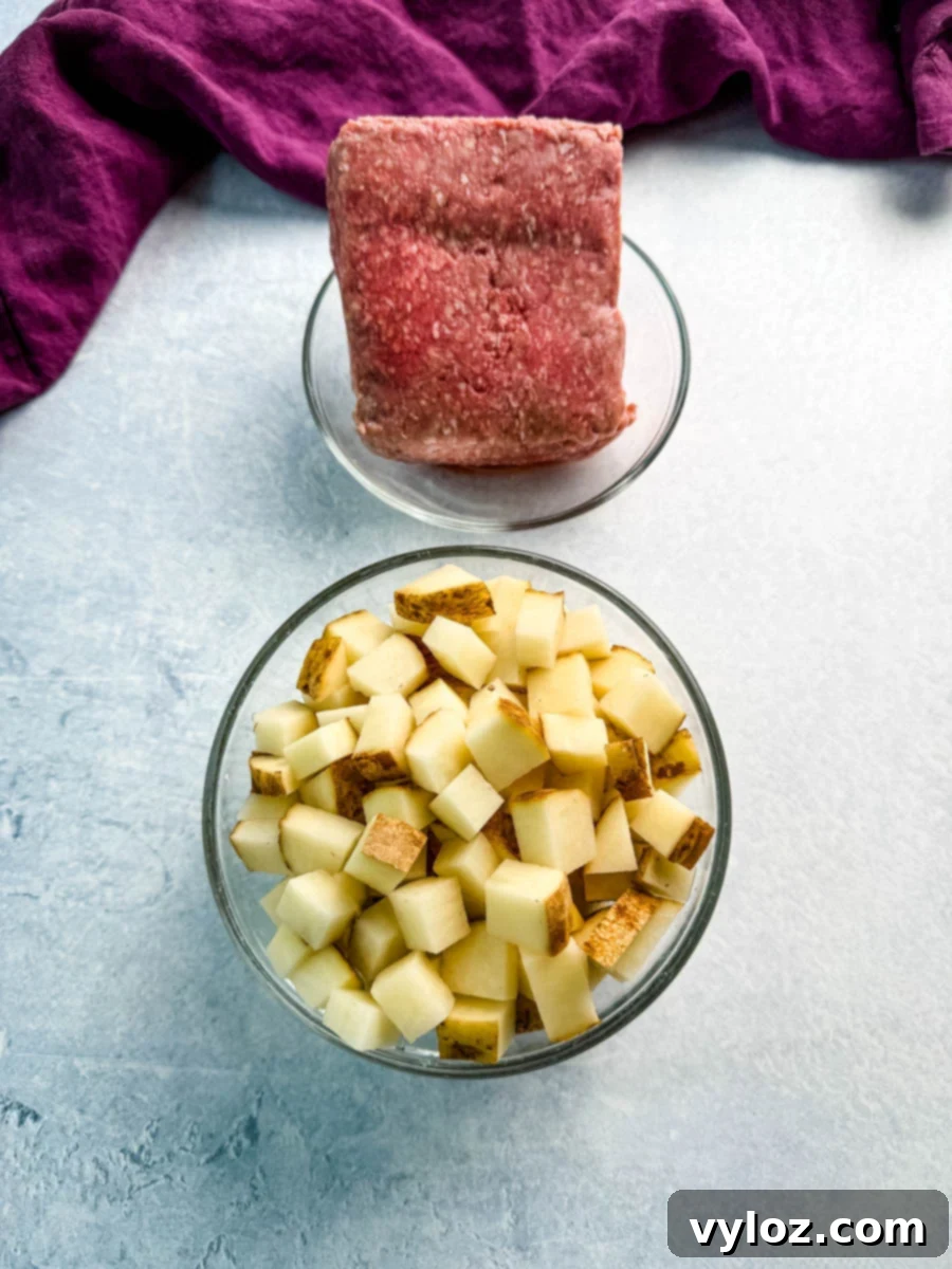 Savory Taco Potatoes 3 Overhead view of raw ground beef and a bowl of diced russet potatoes, ready to be cooked for a taco potato skillet recipe.