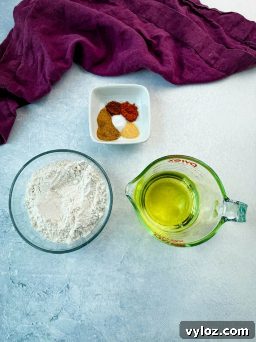 A bowl of all-purpose flour, a Pyrex measuring cup filled with cooking oil, and a dish of spices laid out on a counter next to a purple cloth—ingredients ready for coating and frying chicken.