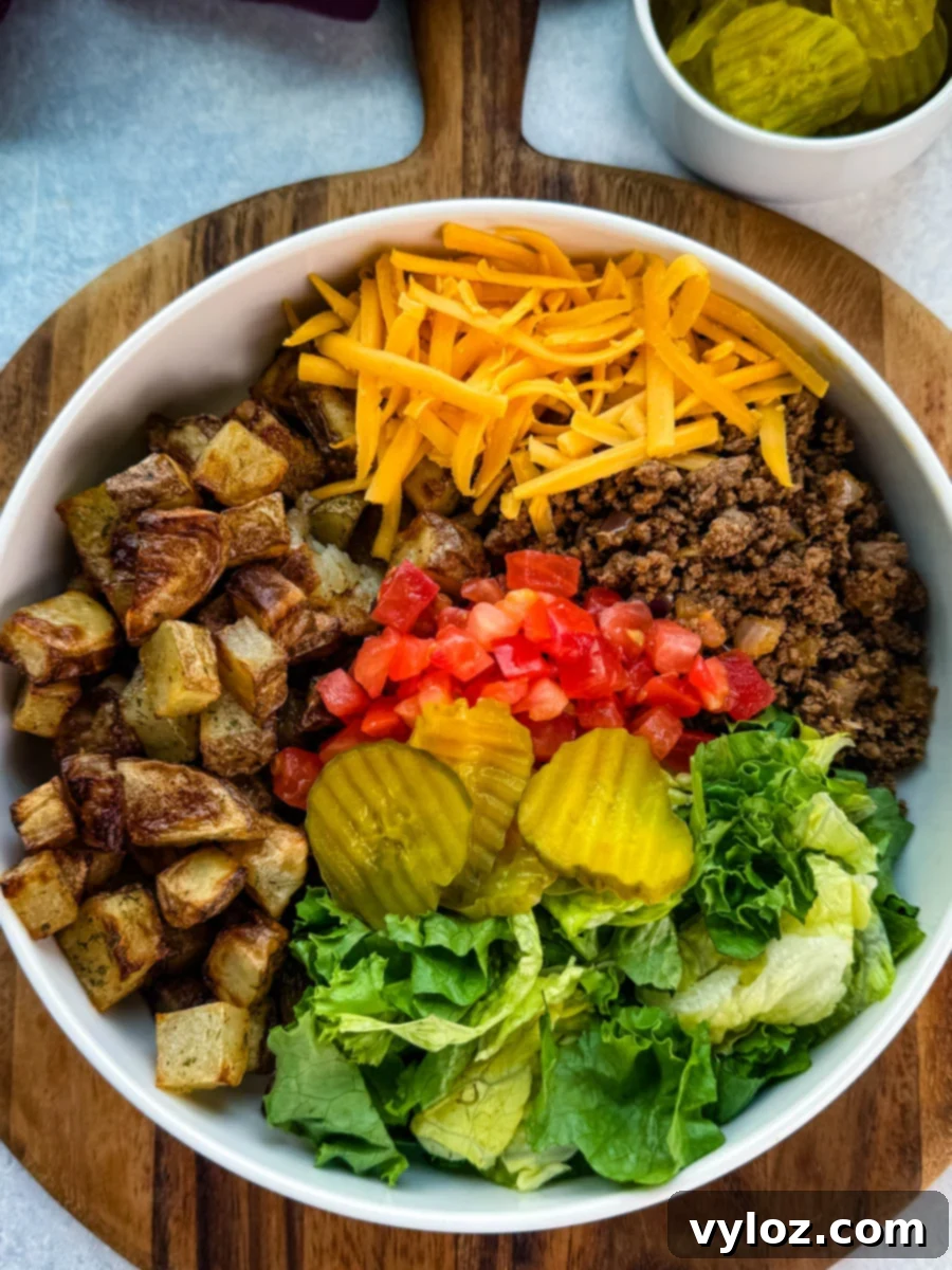 Hero-style image of the Big Mac bowl centered on a wooden board, highlighting all ingredients with a cozy napkin and pickles in the background.