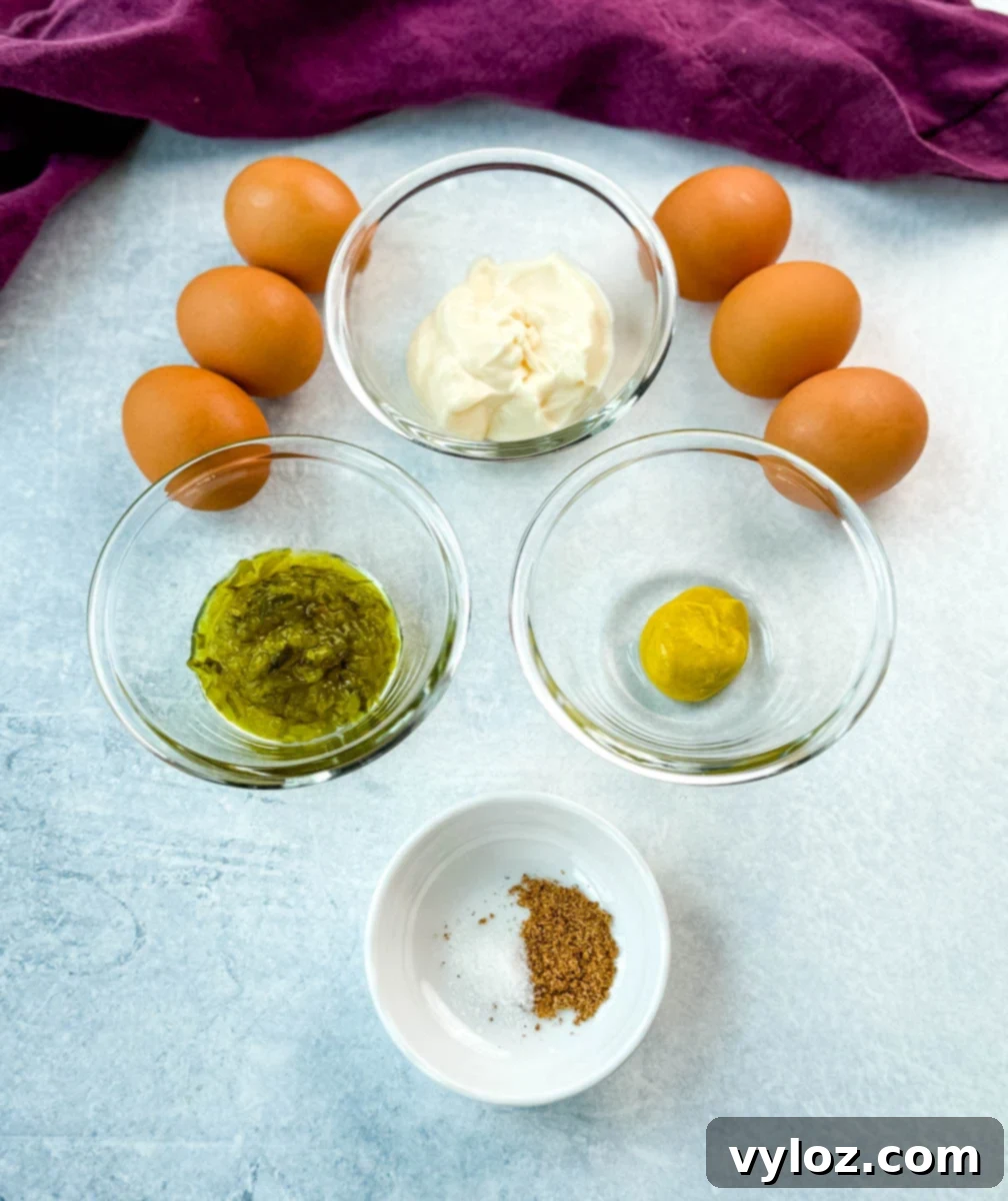 Homestyle Southern Deviled Eggs 4 Ingredients for deviled eggs laid out on a light surface: mayonnaise, relish, mustard, seasoning, and brown eggs.