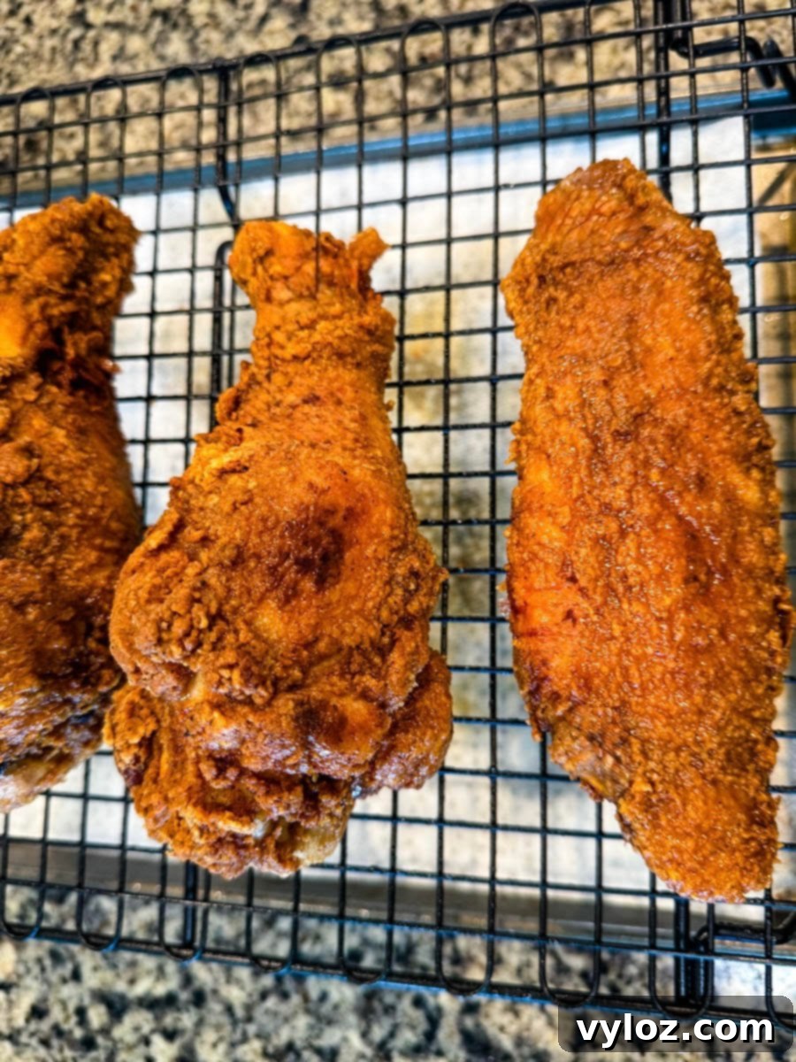 Fried turkey wings cooling on a wire rack, showing their deep golden brown crust.
