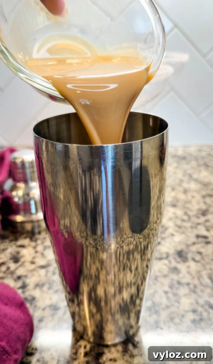 Close-up of Kahlúa being poured into a stainless steel cocktail shaker.
