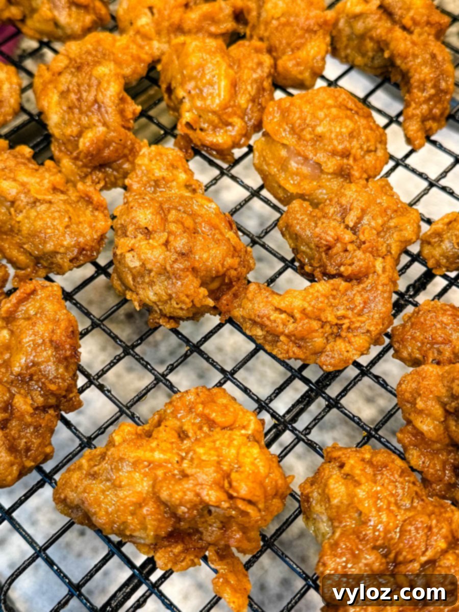 Close-up of crispy fried chicken gizzards cooling on a wire rack after frying.
