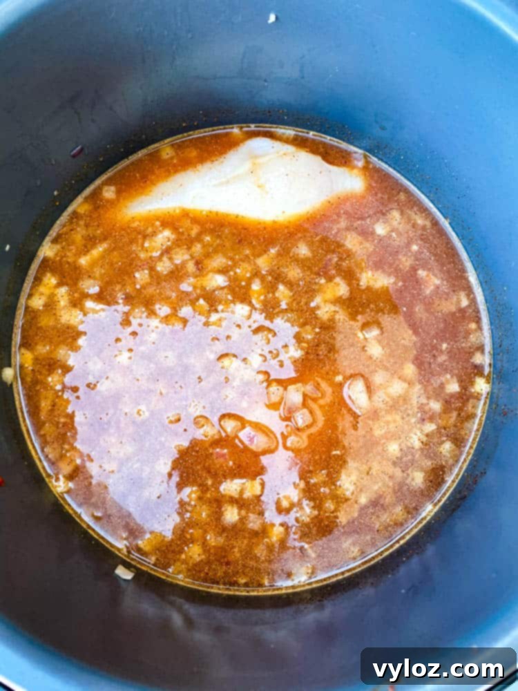 The process of making Instant Pot Chicken Tortilla Soup, showing ingredients in the pot