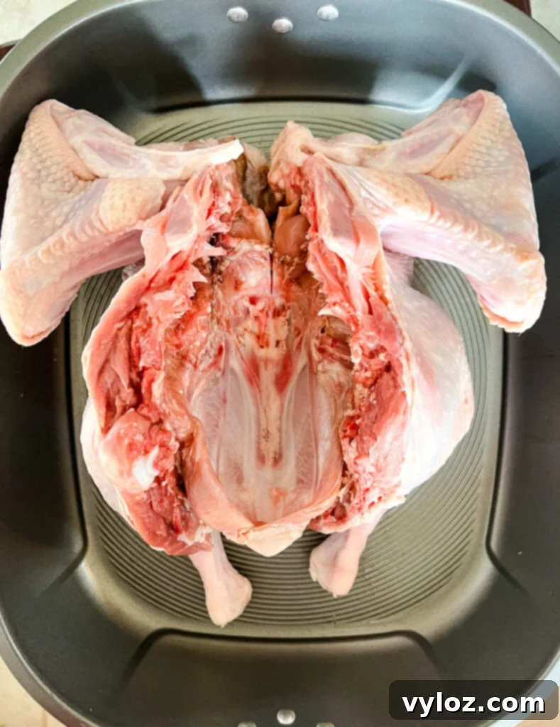 Crispy Skin, Juicy Spatchcock Turkey 4 raw spatchcoked turkey in a pan