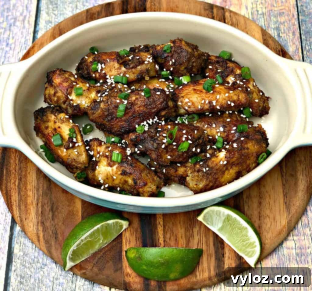 Thai chili chicken wings in a bowl with limes