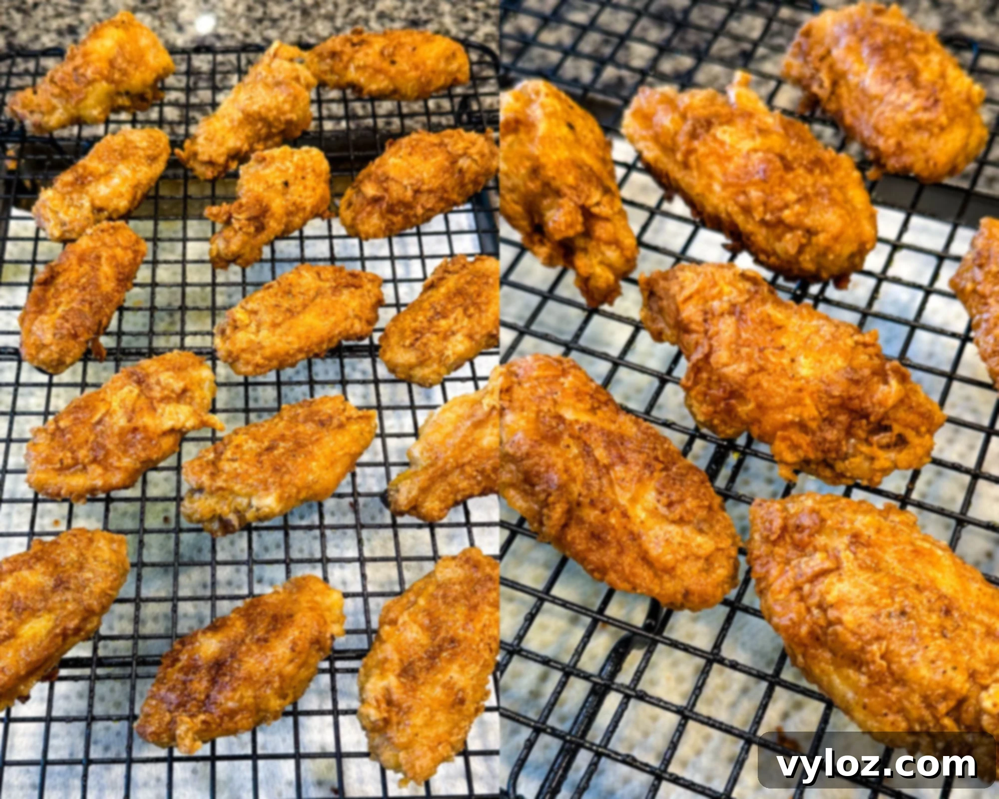 Crispy fried chicken wings resting on a black wire rack, cooling after frying.