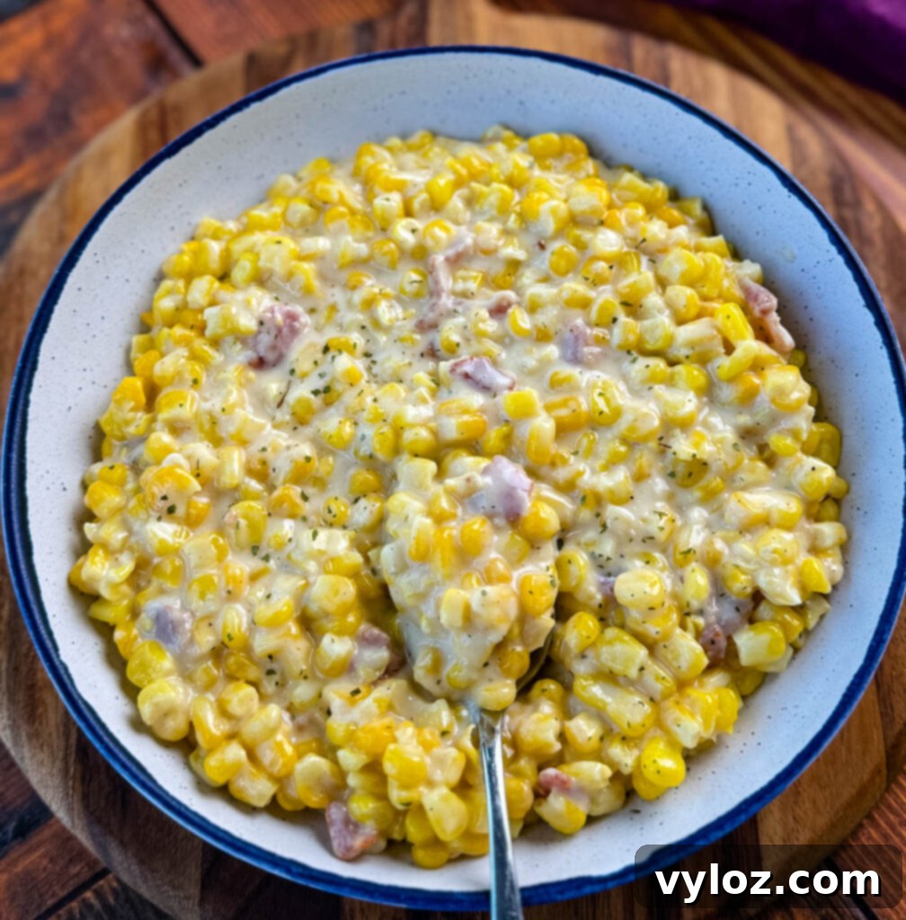 A bowl of creamy Southern Soul Food Creamed Corn with a spoon, ready to be enjoyed.