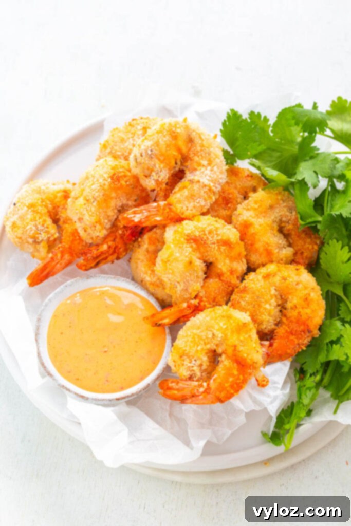 Crispy Air Fryer Bang Bang Shrimp 2 Crispy Air Fryer Bang Bang Shrimp on a white plate with fresh lettuce