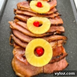 slow cooker crockpot ham on a plate with pineapples and glaze