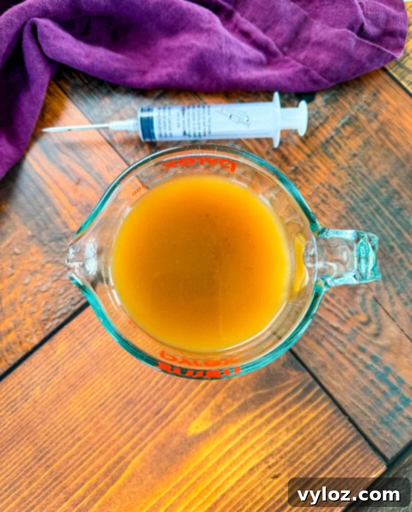 Spicy Cajun Turkey 5 turkey injection marinade in a glass measuring cup and a syringe