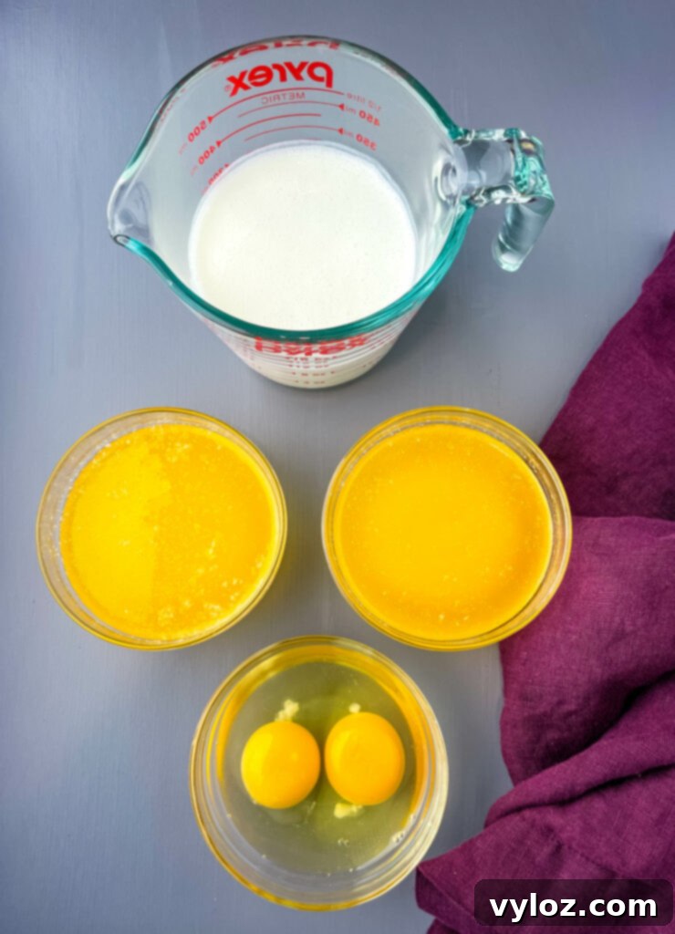 Three glass bowls containing key liquid ingredients: rich buttermilk, golden melted butter, and fresh eggs, ready for mixing.