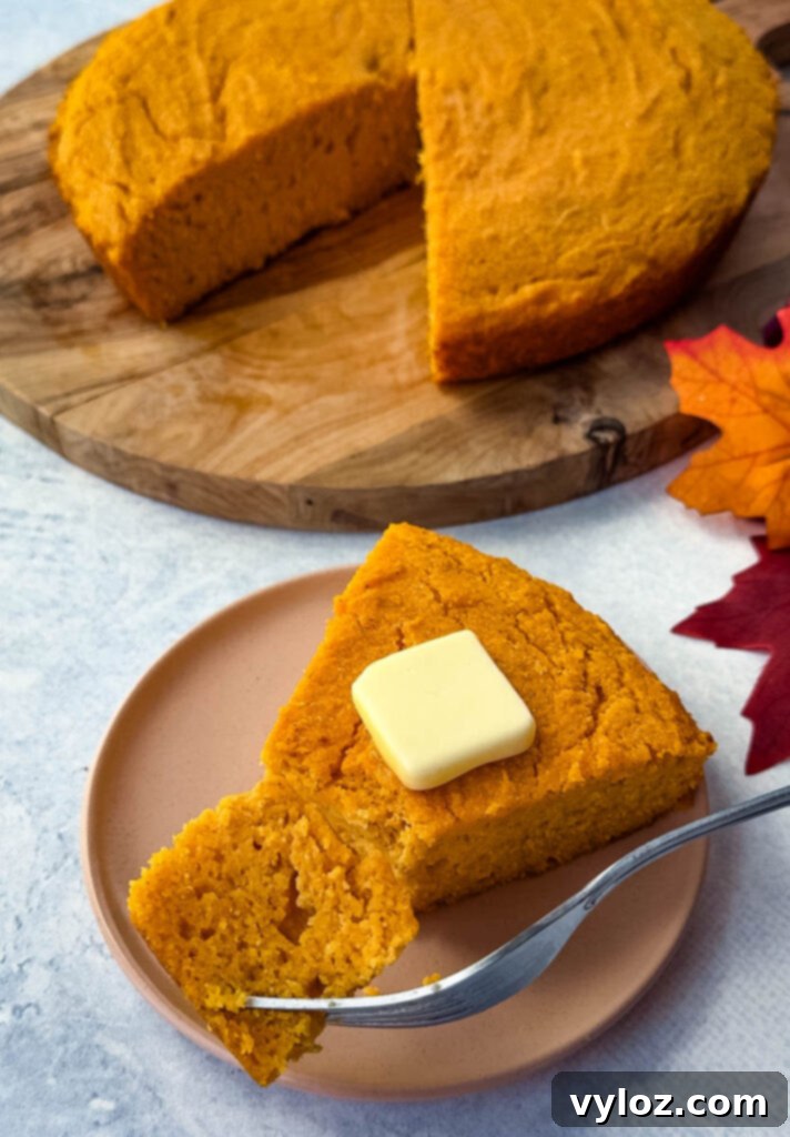 a slice of sweet potato cornbread with butter on a plate with a plate