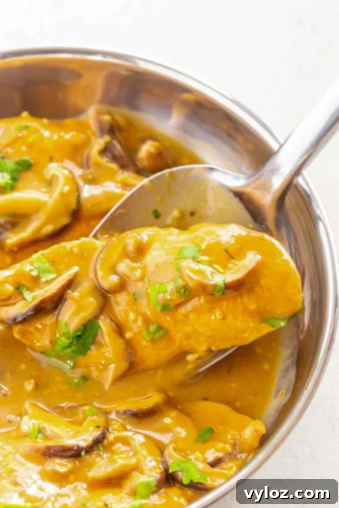 A spoonful of tender Instant Pot chicken marsala with mushrooms and rich sauce.