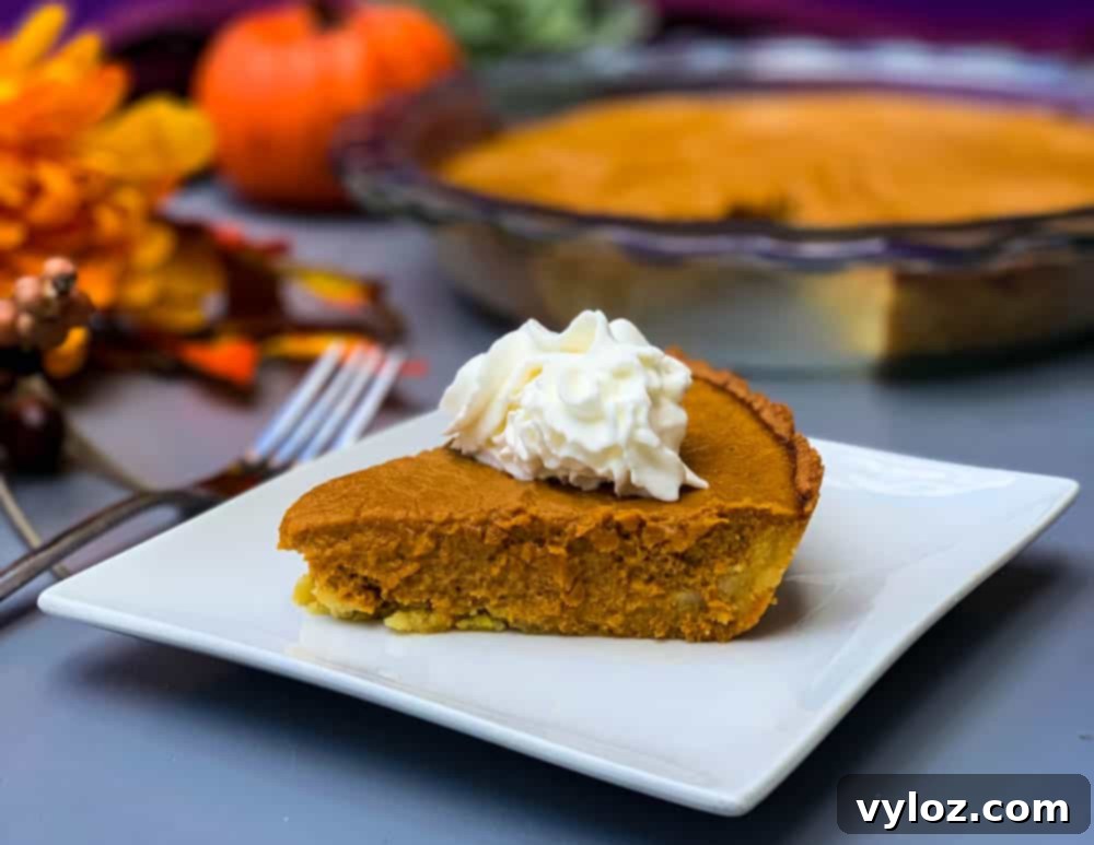 Naturally Sweetened Pumpkin Pie 2 keto low carb pumpkin pie on a white plate with a whole cut pie in the back
