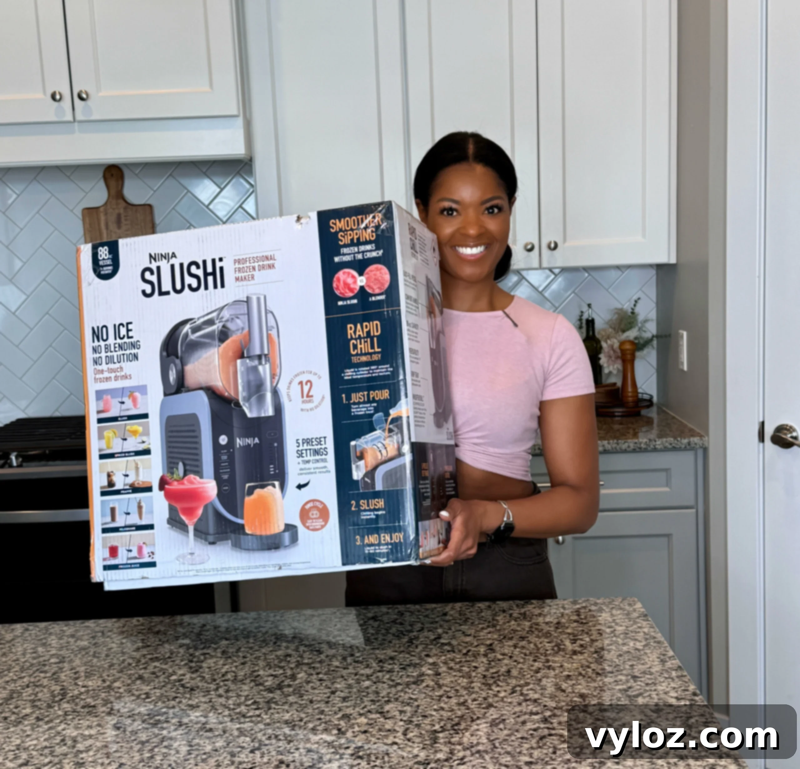 Person proudly holding a Ninja Slushi box in a modern kitchen setting, highlighting the exciting giveaway prize.