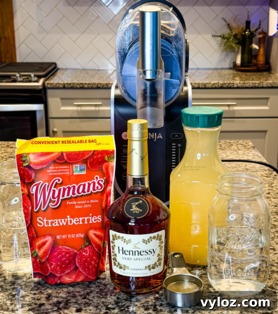 Hennessy Midnight Slush 3 Ingredients lined up on a kitchen counter including frozen strawberries, pineapple juice, water, a bottle of Hennessy, and a Ninja Slushi machine in the background.