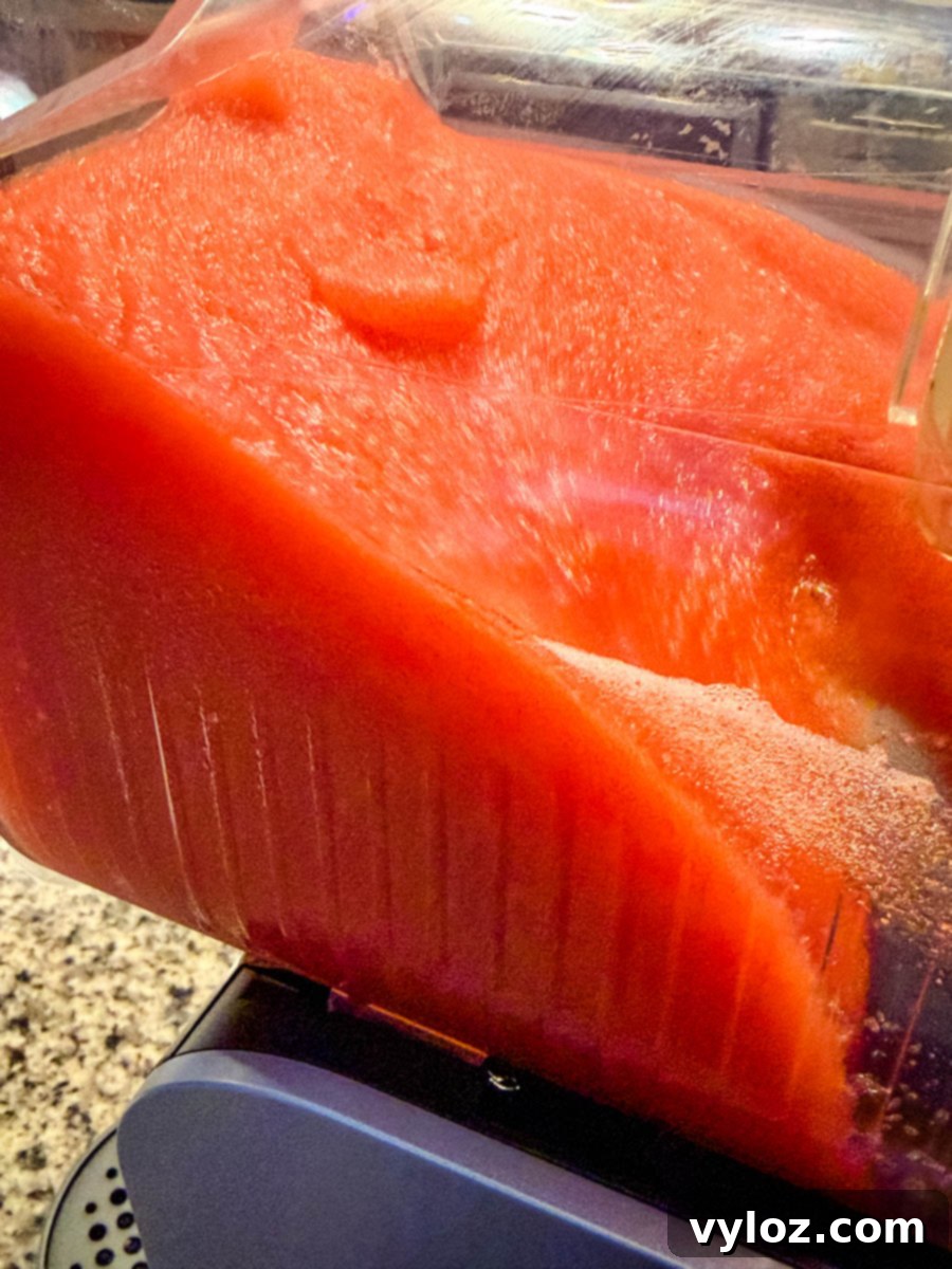 Hennessy Midnight Slush 7 Thick, bright red Hennessy slush mixture freezing inside the Ninja Slushi machine, showing the icy texture up close.