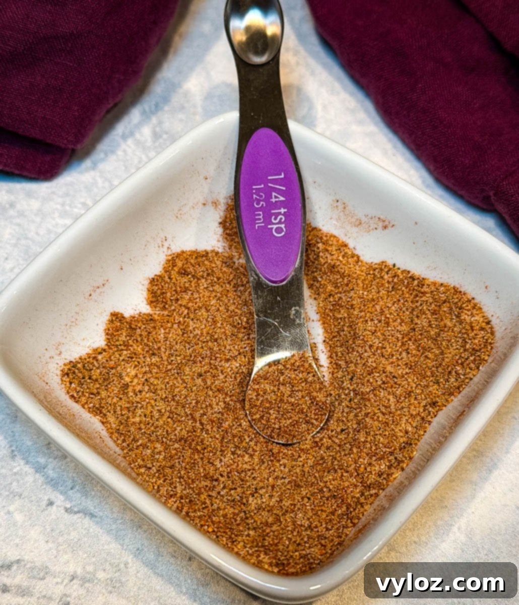 A close-up of a white bowl filled with the fried chicken seasoning, perfectly blended and ready for use. The rich color and texture are clearly visible.