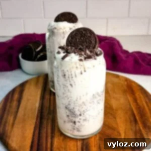 Stealthy Slushy Delight 12 Two Oreo McFlurry-style Ninja Slushi drinks with crushed cookies and whole Oreos on top, placed on a wooden board in front of a bowl of Oreos and a purple cloth.