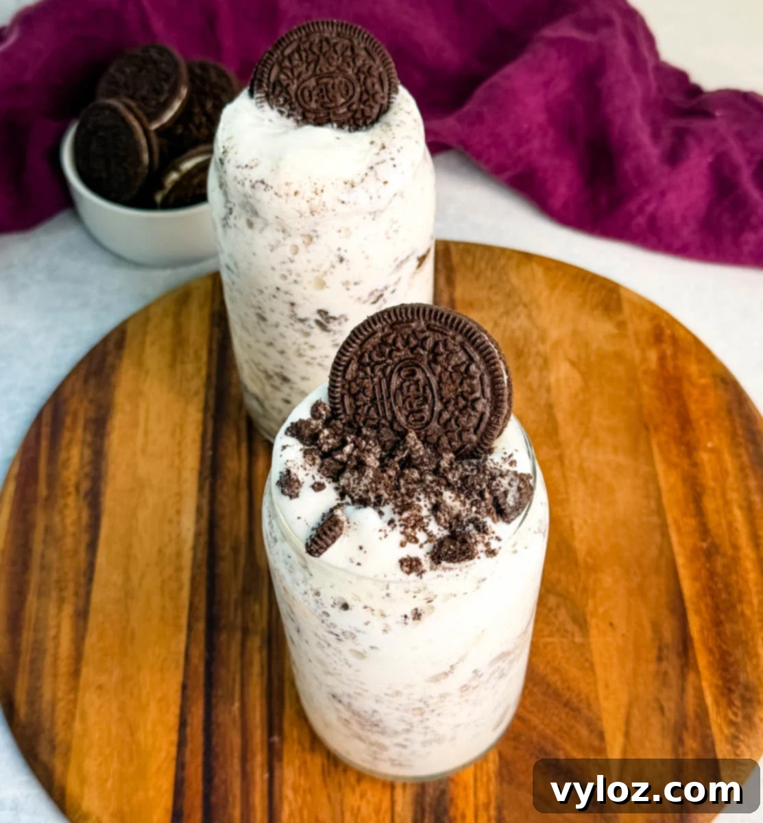 Stealthy Slushy Delight 10 Overhead view of two Oreo Ninja Slushi McFlurries on a wooden board, each topped with crushed Oreos and a whole cookie.