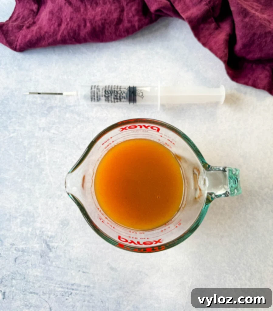 Turkey injection marinade in a clear glass cup, ready to be used