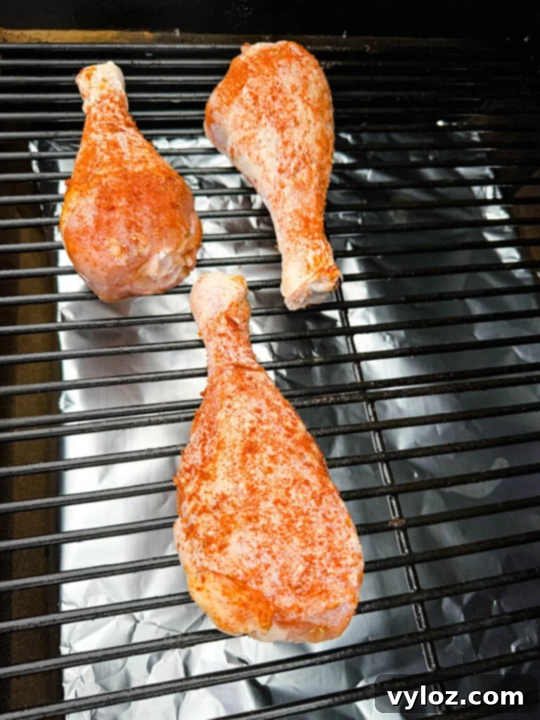 Seasoned, raw turkey legs on a Traeger smoker pellet grill, beginning to cook