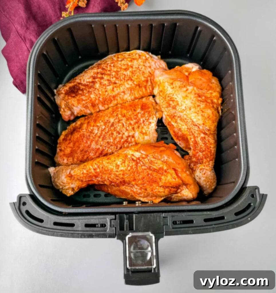 Raw seasoned turkey wings carefully arranged in an air fryer basket, ready for cooking.