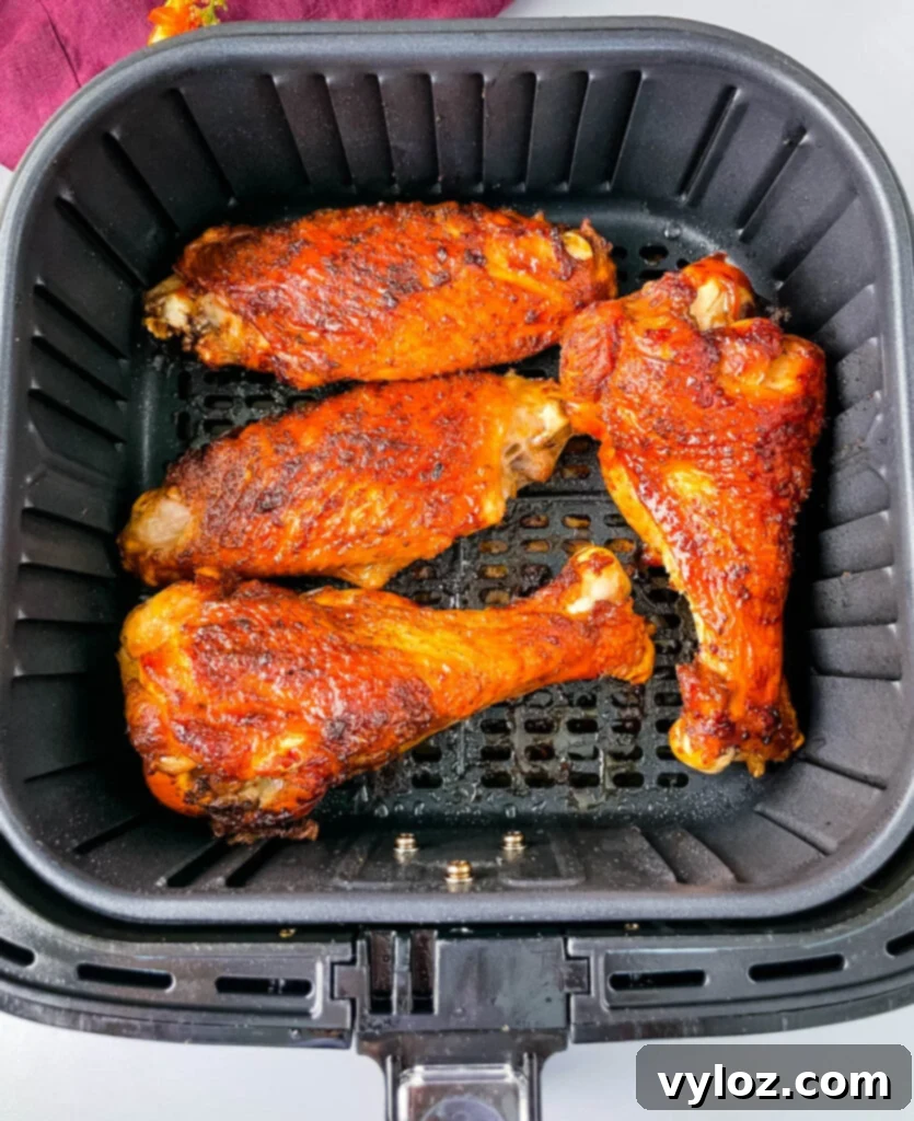 Perfectly cooked, golden-brown turkey wings glistening in the air fryer basket.