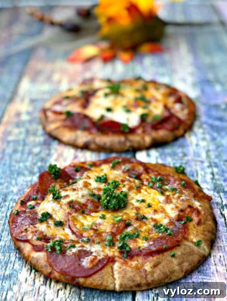 Freshly cooked air fryer pepperoni pizza with melted mozzarella cheese, garnished with fresh basil on a rustic wooden board