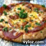 Close-up of air fryer pepperoni pizza with mozzarella cheese on a multi-colored surface