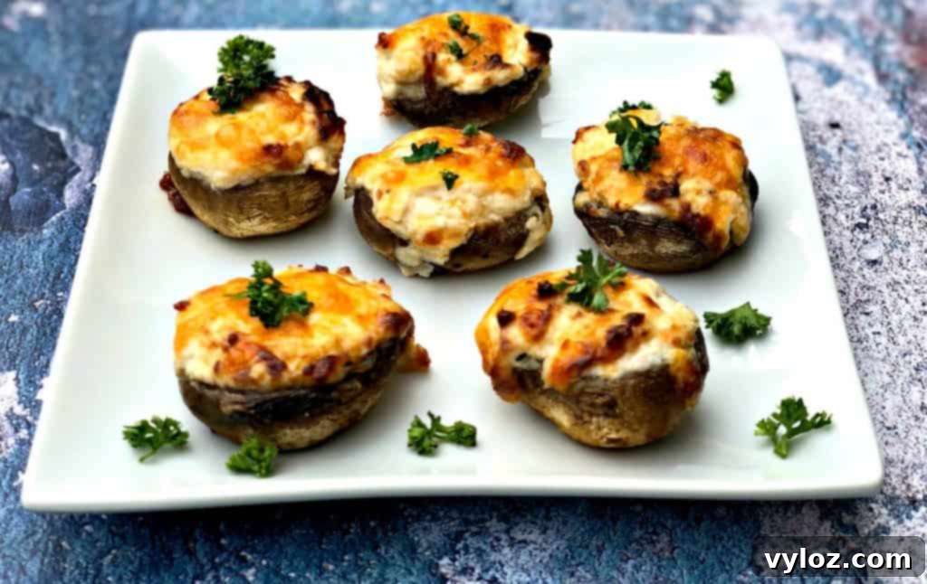 Golden Cheesy Air Fryer Mushrooms 5 Plate of cooked air fryer cheese stuffed mushrooms, hot and ready to eat