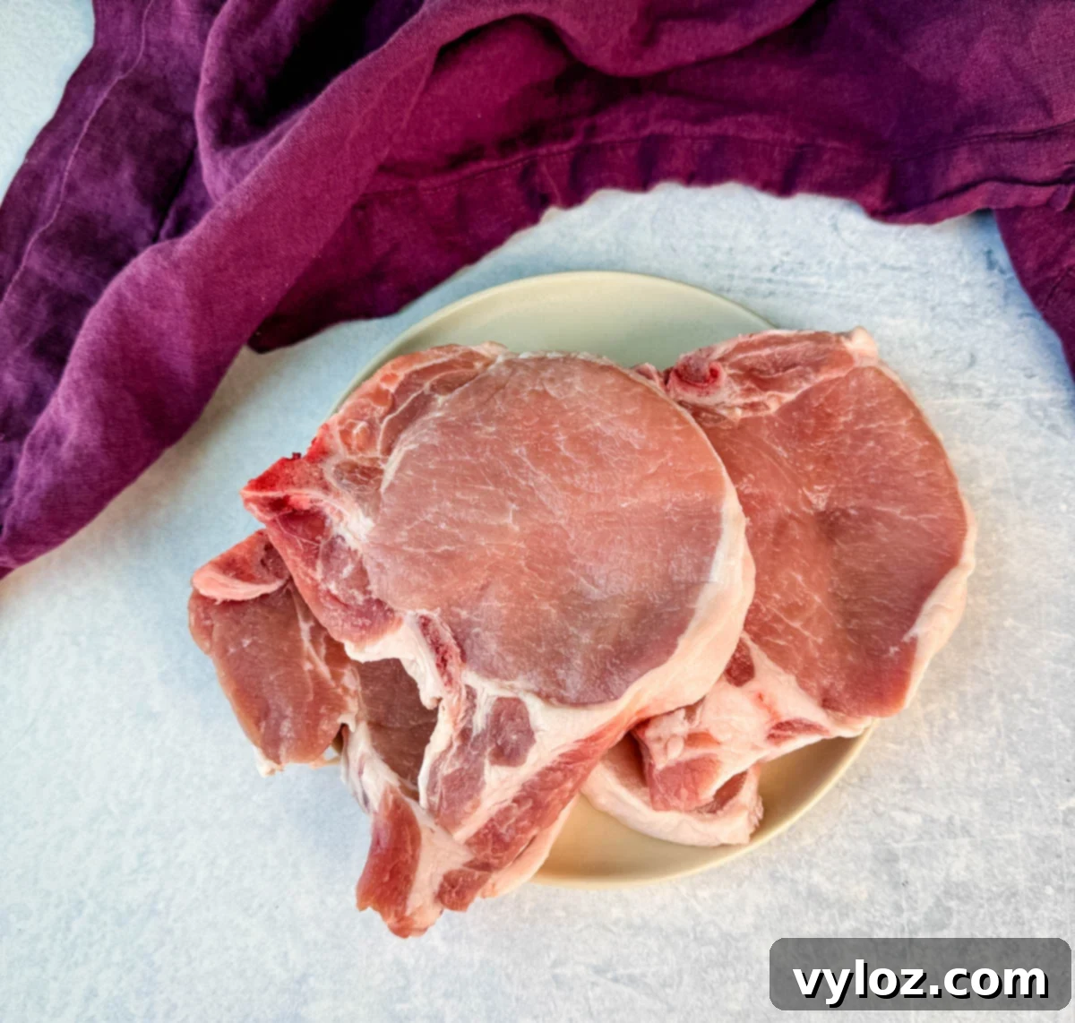A plate of raw bone-in pork chops.