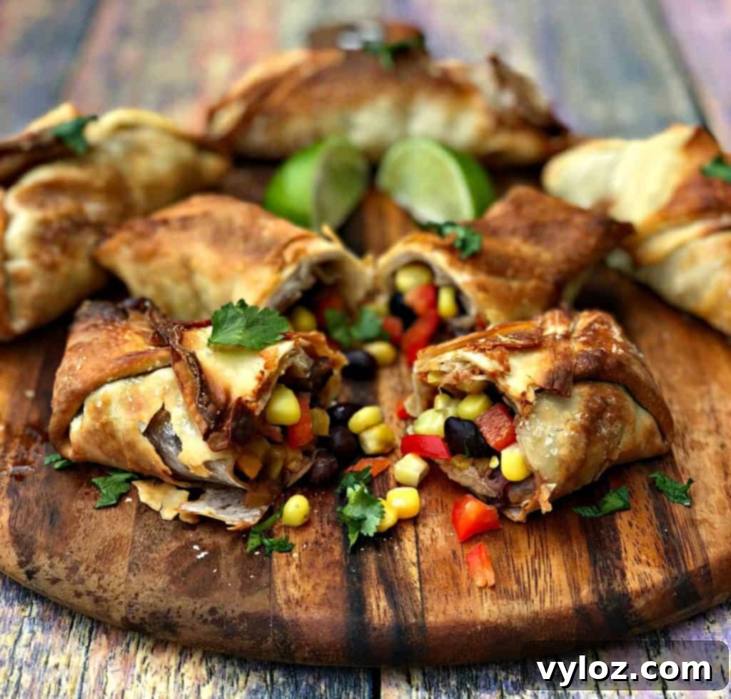 Air fryer southwestern egg rolls cut in half revealing black beans, corn, and red peppers, arranged on a brown cutting board.