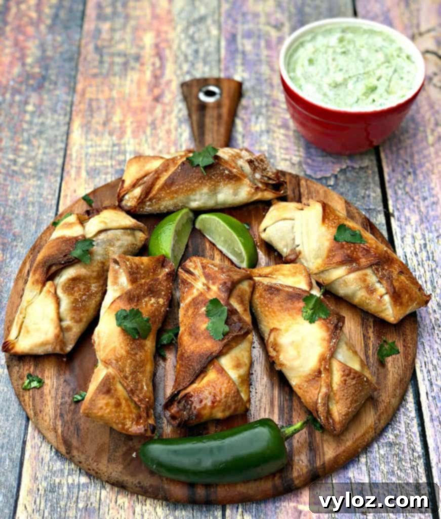 Air fryer southwestern egg rolls, cut in half to show the vibrant black bean, corn, and red pepper filling, artfully arranged on a brown cutting board.
