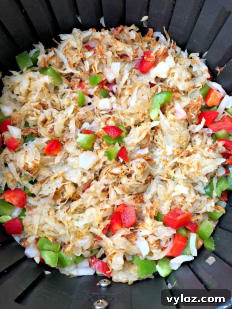Perfectly Crispy Air Fryer Hash Browns 6 hashbrowns cooking in an air fryer, showing their golden texture