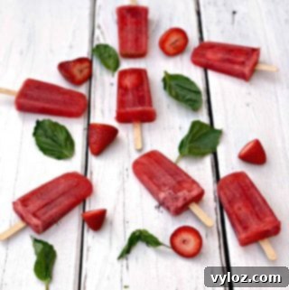 Rosé wine popsicles with basil and strawberries, perfect for a refreshing summer treat.