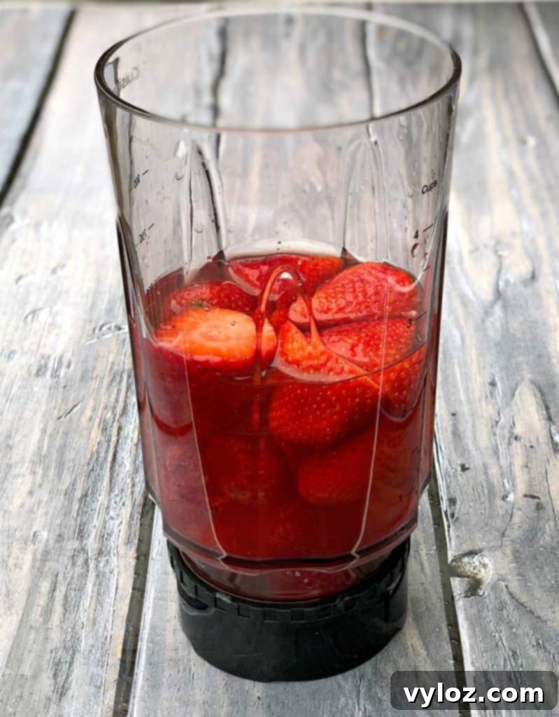 Rosé wine popsicles mixture being blended with fresh fruit, creating a smooth and foamy liquid.